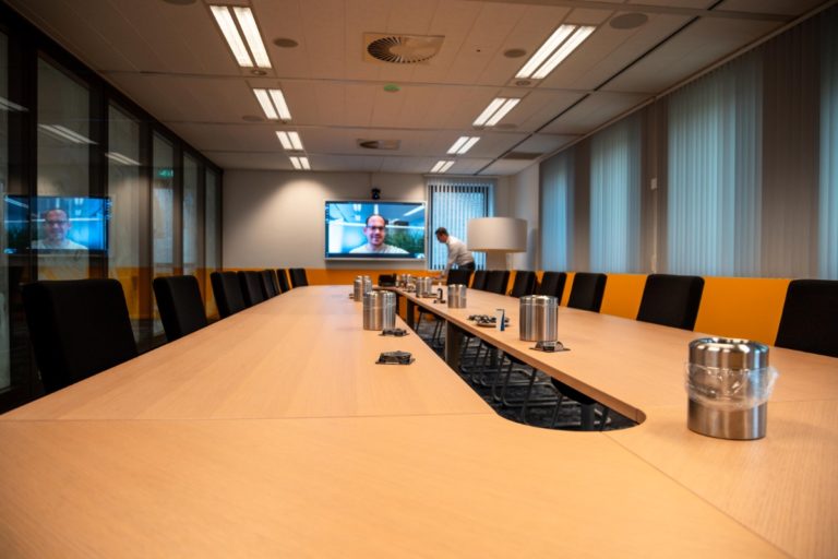 Vergaderruimte ingericht met apparatuur voor hybride vergaderen