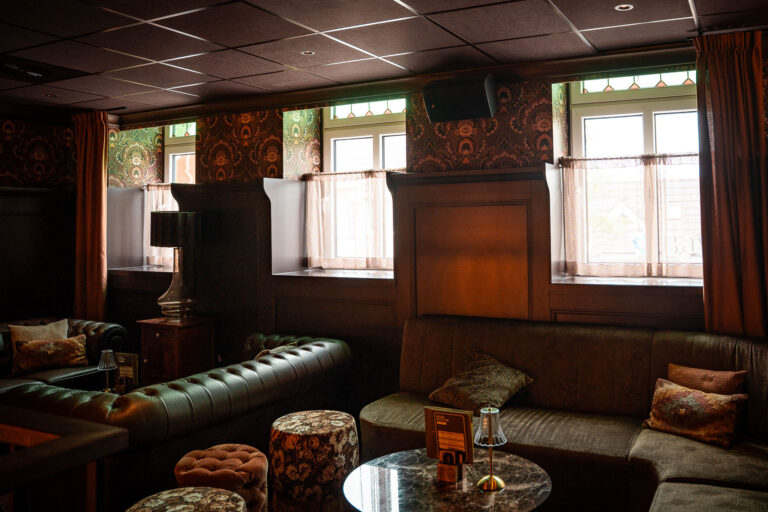 Lounge op verdiepingsvloer restaurant The Vintage, inclusief speaker van geluidsinstallatie.