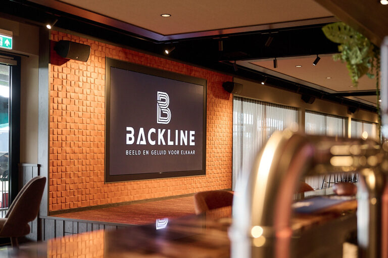 Groot LED-display met links en rechts een speaker, bij podium in business lounge Helmond Sport.