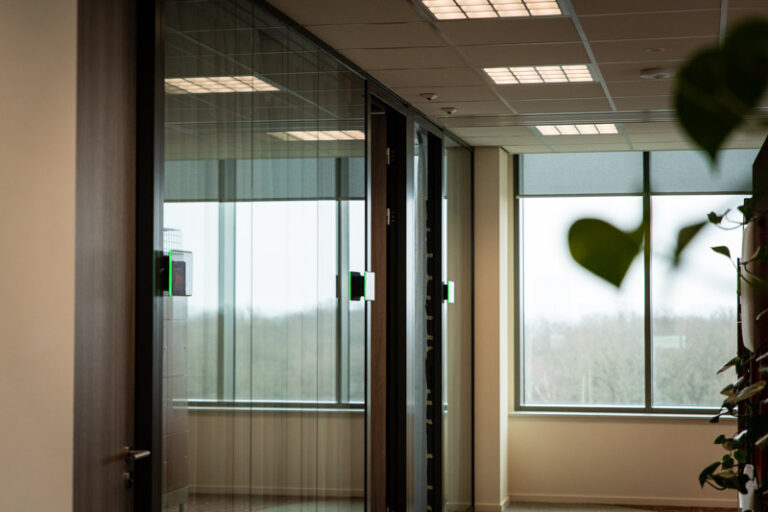 Roombooking panels op een rijtje op de gang van het kantoor.