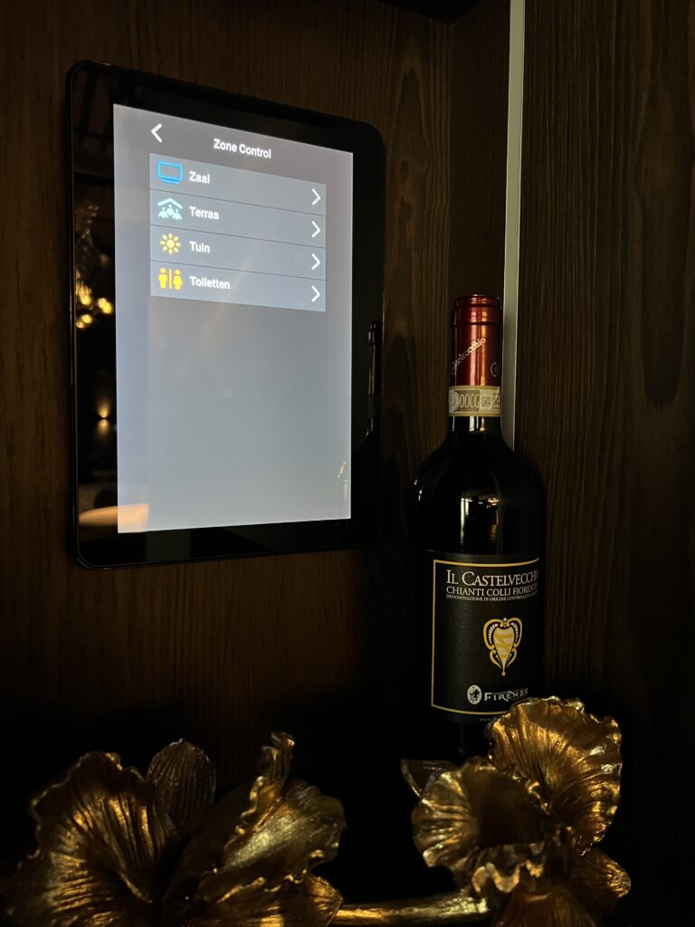 Sfeervolle foto van schermpje voor de bediening van de apparatuur met een fles wijn in beeld.