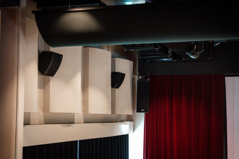 speaker aan wand in een theaterzaal